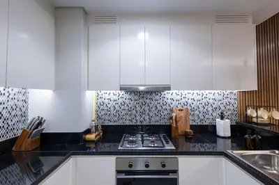 a kitchen with white cabinets and a stove top oven at Top Amenities, Luxury 2BR, 5 min. to Burj Khalifa in Dubai