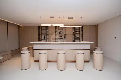 a kitchen with a counter and stools in a room at Luxurious chic getaway for 4, pool view, hammam, sauna, PS5 in Dubai