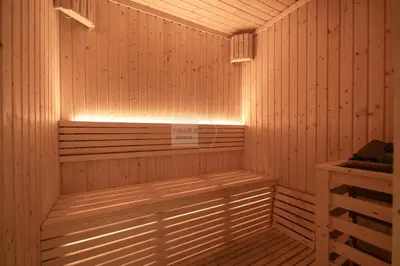 a wooden sauna with a light on the inside at Luxurious chic getaway for 4, pool view, hammam, sauna, PS5 in Dubai