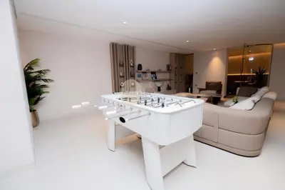 a white living room with a couch and a table at Luxurious chic getaway for 4, pool view, hammam, sauna, PS5 in Dubai