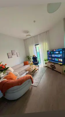 a living room with a couch and a flat screen tv at Ruby home in Dubai