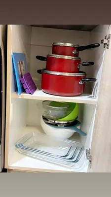 a stack of red bowls and plates in a refrigerator at Ruby home in Dubai