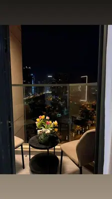 a table with a vase of flowers on a balcony at Ruby home in Dubai