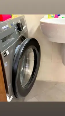 a washing machine in a bathroom next to a toilet at Ruby home in Dubai