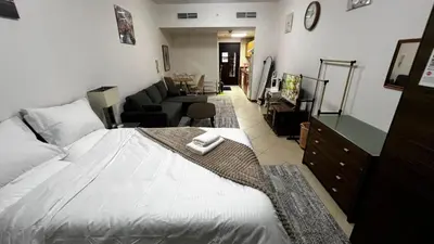 a bedroom with a bed and a living room at Dream home in Dubai