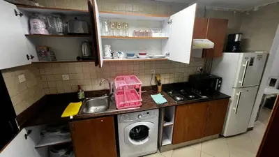 a kitchen with a sink and a washing machine at Dream home in Dubai