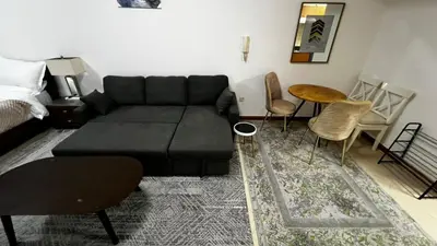 a living room with a black couch and chairs at Dream home in Dubai
