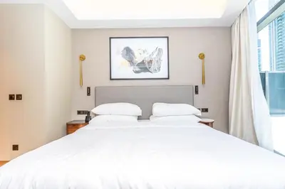 a bedroom with a large white bed and a window at 3BR with Full Burj Khalifa and Dubai Fountain View at Address Opera in Dubai