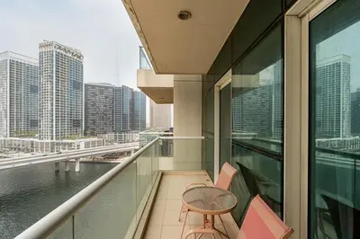 a balcony with a table and chairs on a building at Modern 1BR Unit Close to Canal Walk & Burj Khalifa in Dubai