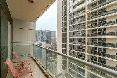 a balcony with a table and chairs and a large building at Modern 1BR Unit Close to Canal Walk & Burj Khalifa in Dubai