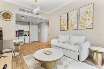 a living room with a white couch and a table at Modern 1BR Unit Close to Canal Walk & Burj Khalifa in Dubai