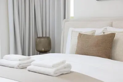 a white bed with white towels on it at Boulevard Chic Modern 2BR with Iconic Street Views in Dubai