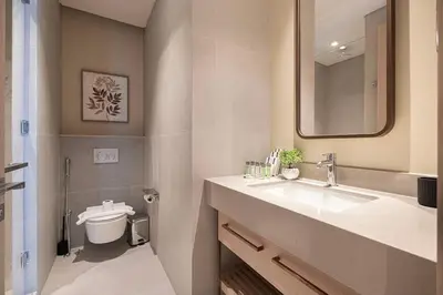 a bathroom with a sink and a toilet and a mirror at Iconic Living Contemporary 2BR at Vida Dubai Mall in Dubai