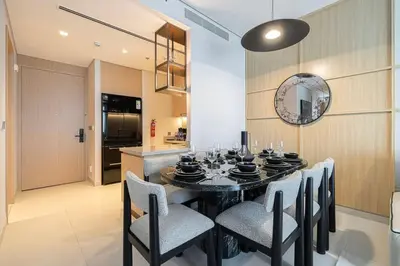 a dining room with a black table and chairs at Heart of Downtown Stylish 2BR at Vida Dubai Mall in Dubai