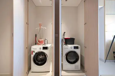 a laundry room with a washer and a washing machine at Downtown Living Massive 4BR at Vida Dubai Mall in Dubai