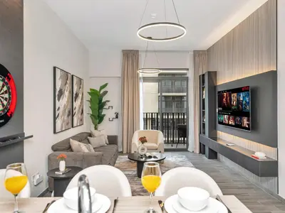 a living room with a couch and a table at Royal Vista - 1BR with Darts Wall at Belgravia Square JVC in Dubai