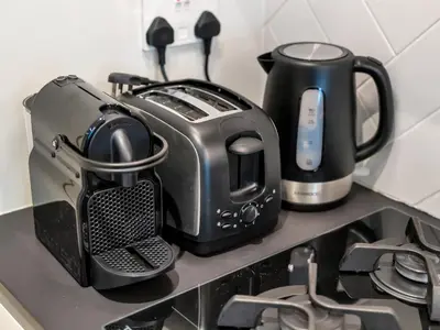a toaster and coffee pot on a kitchen counter at Royal Vista - 1BR with Darts Wall at Belgravia Square JVC in Dubai