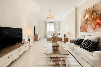 a living room with a couch and a flat screen tv at Stylish Furnsihed Apartments Opposite Five Hotel In JVC in Dubai