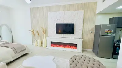a living room with a fireplace with a tv above it at Stylish Furnsihed Apartments Opposite Five Hotel In JVC in Dubai