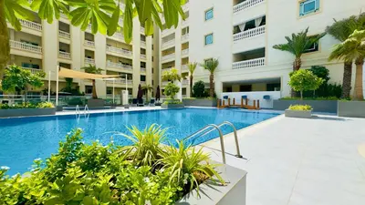 a swimming pool in front of a building at Stylish Furnsihed Apartments Opposite Five Hotel In JVC in Dubai