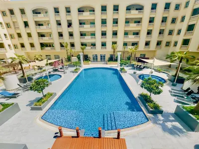 an empty pool in front of a building at Stylish Furnsihed Apartments Opposite Five Hotel In JVC in Dubai