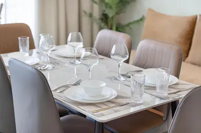 a table with wine glasses and plates on it at Daniels Chic 1BR with City Skyline Views at JVC in Dubai
