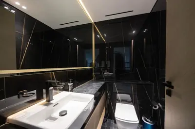 a bathroom with a sink and a toilet and a mirror at Daniels Chic 1BR with City Skyline Views at JVC in Dubai