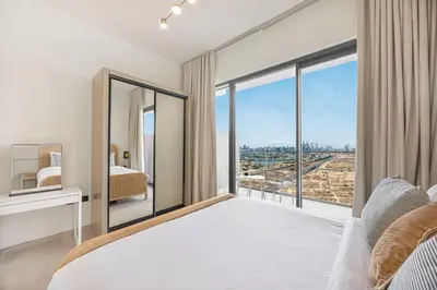 a bedroom with a bed and a large window at Daniels Chic 1BR with City Skyline Views at JVC in Dubai
