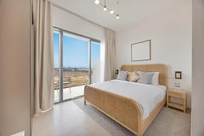 a bedroom with a bed and a large window at Daniels Chic 1BR with City Skyline Views at JVC in Dubai
