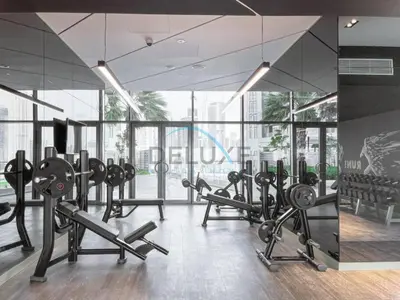 a gym with rows of exercise equipment and large windows at Near Safa Park, Offering Easy Access to Downtown Dubai, Jumeirah Beach and Kite Beach - Aykon City 2 Tower C, Business Bay by Deluxe Holiday Homes in Dubai
