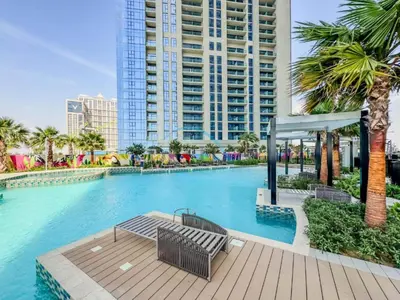 a swimming pool with a bench and a building at Near Safa Park, Offering Easy Access to Downtown Dubai, Jumeirah Beach and Kite Beach - Aykon City 2 Tower C, Business Bay by Deluxe Holiday Homes in Dubai