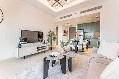 a living room with a couch and a tv at Just Moments from Coca-Cola Arena and Metro 1BR, Surrounded by a Vibrant Array of Retail and Dining Outlets, Viridian, Al Wasl by Deluxe Holiday Homes in Dubai