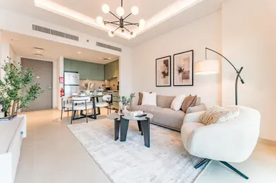 a living room with a couch and a table at Just Moments from Coca-Cola Arena and Metro 1BR, Surrounded by a Vibrant Array of Retail and Dining Outlets, Viridian, Al Wasl by Deluxe Holiday Homes in Dubai