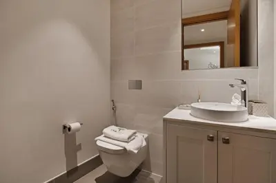 a bathroom with a sink and a toilet and a mirror at Luxury 4BR Apartment Burj Khalifa & Mall Views in Dubai