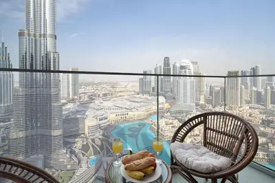 a table with a plate of food on top of a building at Luxury 4BR Apartment Burj Khalifa & Mall Views in Dubai