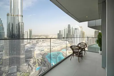a balcony with two chairs and a view of a city at Luxury 4BR Apartment Burj Khalifa & Mall Views in Dubai