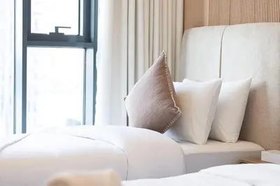 a bedroom with white pillows on a bed with a window at 3 Bedroom Apartment with Full Skyline Views In Creek Harbour in Dubai