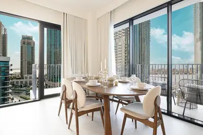 a dining room with a table and chairs and large windows at 3 Bedroom Apartment with Full Skyline Views In Creek Harbour in Dubai