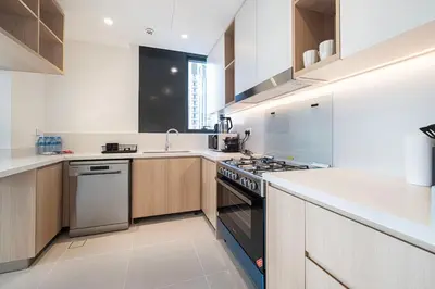 a kitchen with white counters and a stove top oven at 3 Bedroom Apartment with Full Skyline Views In Creek Harbour in Dubai