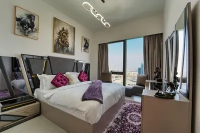 a bedroom with a large bed with purple pillows at ROME x DXB with Full Burj and Fountain View in Downtown Dubai in Dubai