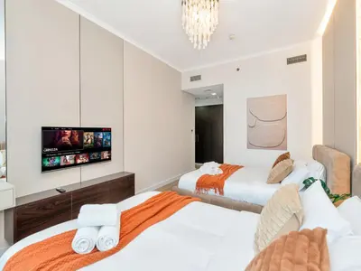 two beds in a room with a flat screen tv at Ultra Stylish Luxury Flat w Harbour View in Dubai Marina, Sleeps 10 pax in Dubai