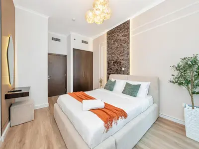 a white bedroom with a large white bed with an orange blanket at Ultra Stylish Luxury Flat w Harbour View in Dubai Marina, Sleeps 10 pax in Dubai