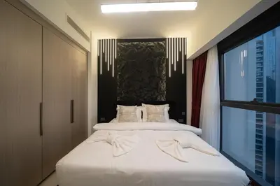 a bedroom with a bed with white sheets and a window at Noir x DXB a High Floor 1BDR in Downtown Dubai in Dubai