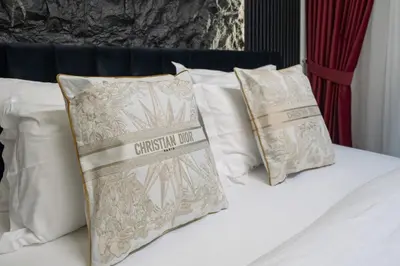 a bed with white pillows with a christmas sign on it at Noir x DXB a High Floor 1BDR in Downtown Dubai in Dubai