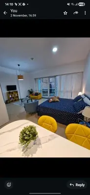 a living room with a bed and chairs in a room at Lovely cozy studio in Tecom near Metro in Dubai