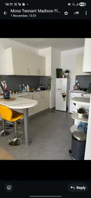 a kitchen with a white table and yellow chairs at Lovely cozy studio in Tecom near Metro in Dubai