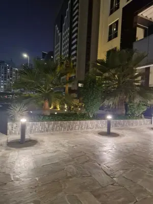 a courtyard with two lights in a city at night at Lovely cozy studio in Tecom near Metro in Dubai