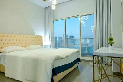 a bedroom with a large bed and a large window at Luxestay Holiday Homes in Dubai