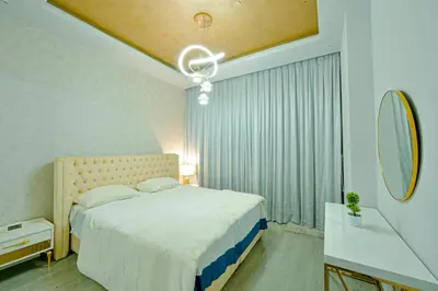 a bedroom with a large bed and a mirror at Luxestay Holiday Homes in Dubai