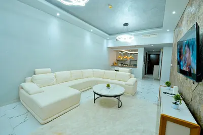 a living room with a white couch and a table at Luxestay Holiday Homes in Dubai
